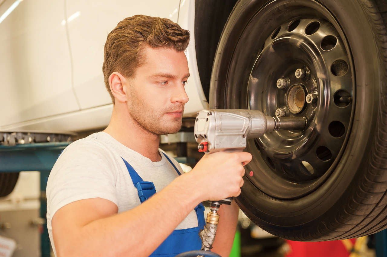 Photo d'un mécanicien qui change un pneu
